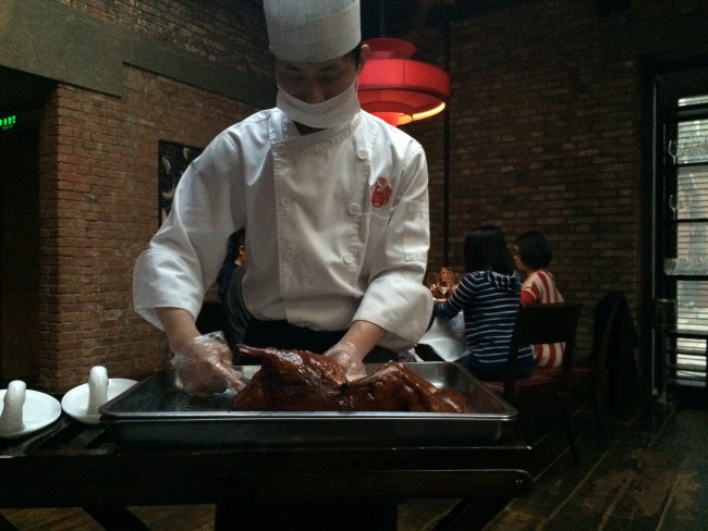 Waiter carves Peking duck at Duck De Chine